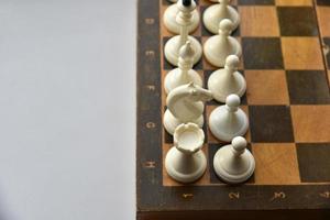 An old chessboard with white and black pieces photo