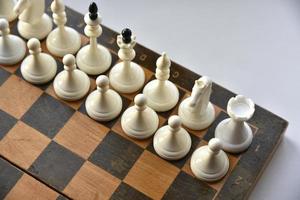 An old chessboard with white and black pieces photo