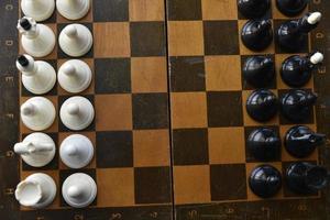 An old chessboard with white and black pieces photo