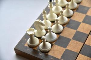 An old chessboard with white and black pieces photo