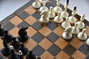 An old chessboard with white and black pieces photo