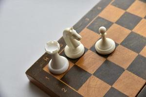 An old chessboard with white and black pieces photo