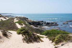 hermosa costa del alentejo. sendero de arena a lo largo de la costa. viejo barco náutico oxidado. día soleado. foto