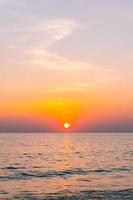 Sunset reflection sea. beautiful sunset behind the clouds and blue sky above the over sea landscape background photo