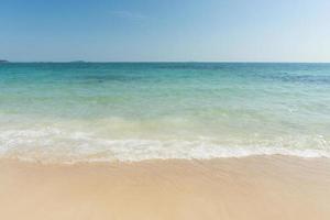 playa y olas mar tropical con cielo azul en el fondo del día soleado. copie el espacio foto