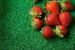 Ripe strawberry with leaves on green grass photo