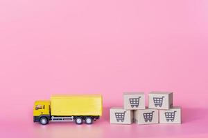 Logistics, and delivery service - Cargo truck and paper cartons or parcel with a shopping cart logo on Pink background. Shopping service on The online web and offers home delivery. photo