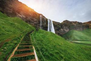 Seljalandfoss waterfall at sunset. Bridge over the river. Fantas photo