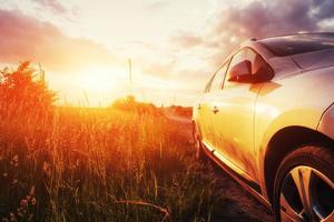 coche de carretera en un campo al atardecer. ucrania europa foto