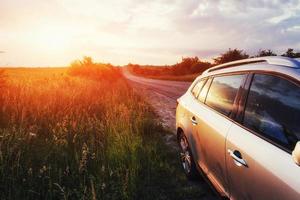 coche de carretera en un campo al atardecer. ucrania europa foto