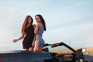 Two women in a black car on the roadside roads photo