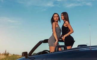 Beautiful two women sitting in a convertible photo