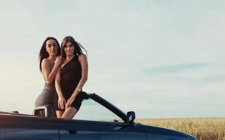 Girls posing for the camera in a black convertible photo