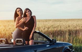 Girls posing for the camera in a black convertible photo