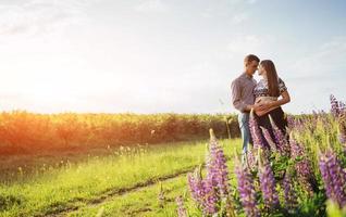 Happy beautiful girl pregnant with her husband outdoor. photo