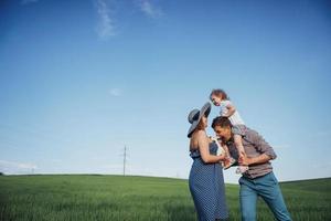 familia feliz de tres personas abrazándose en las calles foto