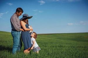 familia feliz de tres personas abrazándose en las calles foto