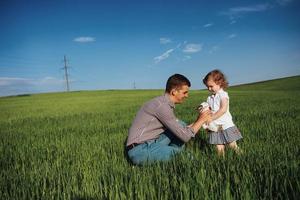 padre feliz y conejo bebé en las manos en el campo foto