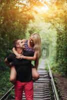 Loving couple in a tunnel of green trees on railroad photo