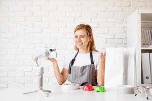 Young woman groomer blogger speaking looking to camera, talking about dog food and pet care equipment photo