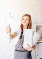 Young woman groomer blogger speaking looking to camera, talking about dog food and pet care equipment photo