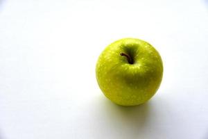 una deliciosa manzana verde sobre un fondo blanco foto