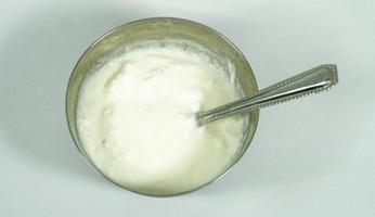 tazón con yogur cremoso sobre fondo blanco foto