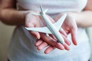 Female woman hands holding small toy model plane. Travel by plane vacation weekend adventure trip journey ticket tour aviation delivery concept. Symbol of international freedom. photo