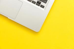 Keyboard laptop computer isolated on yellow desk background. Modern Information technology and sofware advances photo