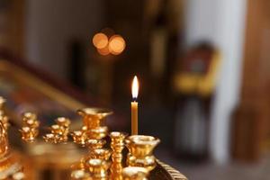 Iglesia Ortodoxa. cristiandad. decoración interior festiva con velas encendidas e icono en la iglesia ortodoxa tradicional en vísperas de pascua o navidad. religión fe orar símbolo. foto