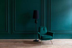 Beautiful luxury classic blue green clean interior room in classic style with green soft armchair. Vintage antique blue-green chair standing beside emerald wall. Minimalist home design.