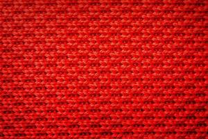 Red knitting fabric weaving as background. Abstract red background. photo