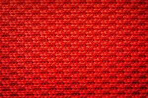 Red knitting fabric weaving as background. Abstract red background. photo