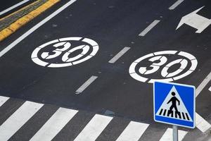 Señal de límite de velocidad de 30 kilómetros por hora pintada en la carretera de la ciudad foto