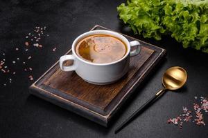 Chicken noodle soup with parsley and vegetables in a white plate photo