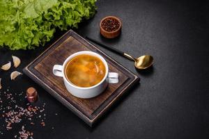 Chicken noodle soup with parsley and vegetables in a white plate photo