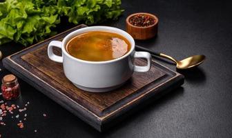 Chicken noodle soup with parsley and vegetables in a white plate photo