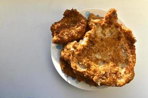 Pieces of fried pork meat on a plate photo