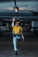 Cheerful black woman in trendy outfit having fun on parking lot photo