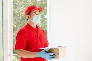 A delivery man wearing a red dress holds a parcel box.