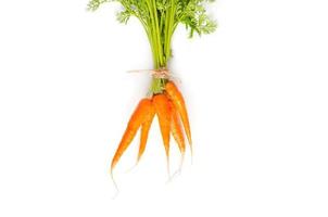 zanahorias frescas con follaje verde sobre fondo blanco.
