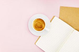 Two notebooks for writing and a white porcelain cup with coffee photo