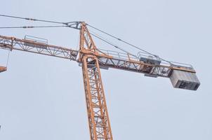 Construcción de grúa en un sitio de construcción sobre el cielo azul foto