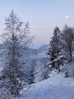noche y luz de la luna sobre las montañas nieve y lagos, noruega. foto