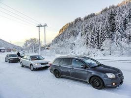 Cars stop in a snowy landscape through mountains Norway. photo