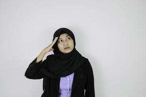 gesto serio de ensueño joven islámica asiática con pañuelo en la cabeza. foto