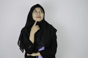 gesto feliz y soñador joven mujer islámica asiática con pañuelo en la cabeza. foto