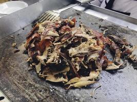 Sliced Peking Duck and cleaver on cutting board on steel roaster photo