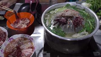 carne de porco grelhada uma comida de festa popular na Tailândia, carne de porco e outras carnes são grelhadas em uma panela e mergulhadas em molhos para comer. video