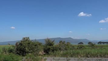 het landschap van de spoorlijn van thailand die door velden en velden en bergen en bossen en rivieren loopt. video